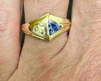 14kt diamond, tanzanite ring. Three bezel set diamonds mounted beside trillion cut tanzanite. Marked 14K/Adamor. Ring size 6.5