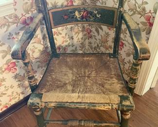 One of two vintage Hitchcock-style armchairs with a rush seat and hand-painted floral stenciling