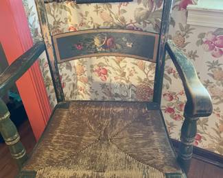 One of two vintage Hitchcock-style armchairs with a rush seat and hand-painted floral stenciling