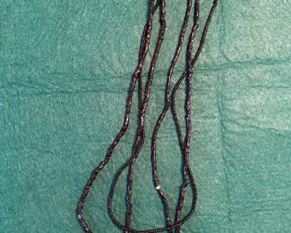 Three strands of black glass beads