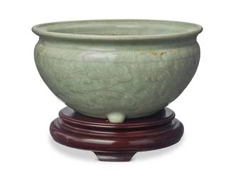72
A Chinese Longquan celadon bowl
Ming Dynasty (1368-1644) or later
The tripod bowl with molded floral motifs to body and meandering motif to rim, set in a hardwood stand
Bowl: 5.25" H x 10" Dia.; Base: 2" H x 8.125" Dia.
Estimate: $700 - $900