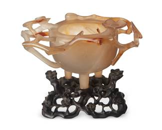 176
A Chinese carved agate tripod vessel
Qing Dynasty (1644-1912) or later
With branch-form decorations and flower and leaf accents, raised on a carved hardwood base
Stone: 3.625" H x 5.625" W x 3.5" D; Stand: 1.75" H x 4.125" W x 2.125" D
Estimate: $700 - $900