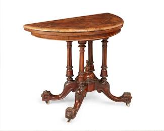 357
A Victorian carved wood fold-over games table
19th century
The demilune top with fold-over and swivel action, opening to a velvet-lined interior over four turned supports raised on curved legs ending in block feet
Stored: 28.5" H x 36" W x 18" D; Open: 35.75" Dia.
Estimate: $200 - $400