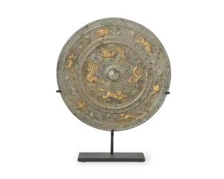 213
A Chinese silvered and gilt-bronze mirror
Tang Dynasty (618-907 CE) or style
The circular mirror cast with running creatures within an outer border of animals and grape vines, set in an enameled metal stand
Mirror: 8.62" Dia; Overall: 10.875" H
Estimate: $2,000 - $3,000