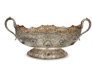 110
A repoussé sterling silver center bowl
20th century
Marked to underside: Nisan / 925 / FIRST CLASS
The footed oblong bowl with opposed foliate-form handles, featuring pierced filigree border above repoussé shell and foliate motifs
9.625" H x 21.875" W x 10" D
85.9 oz. troy approximately
Estimate: $2,000 - $3,000