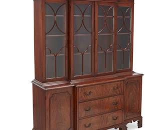 353
A George III-style mahogany breakfront cabinet
Mid-20th century
Appears unmarked
The broken swan neck and latticework pediment cresting an architectural cornice, featuring four astragal glazed cabinet doors, each revealing three illuminated adjustable shelves, the lower console with three locking drawers centering opposed locking cabinet doors, each revealing a single shelf, electrified
Lower console: 34.5" H x 62" W x 18.5" D; Upper console: 55" H x 61" W x 15.25" D
Estimate: $800 - $1,000