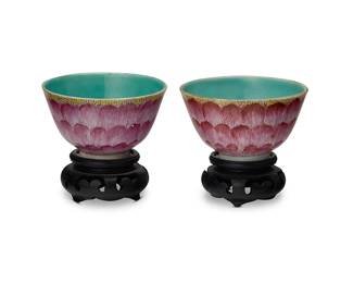86
A pair of Chinese Famille Rose porcelain lotus bowls
Possibly Qing Dynasty (1644-1912) or later
Bearing red underglaze reign mark for Jiaqing Period (1796-1820)
Each footed bowl with red glazed lotus leaf pattern to exterior and pale blue/green glaze interior, set on a carved wood stand
2 pieces
Each bowl: 1.75" H x 2.875" Dia.; Each stand: 1.125" H x 2.125" Dia.
Estimate: $1,000 - $1,500