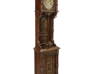 401
An Ansonia Renaissance Revival tall case clock
Late 19th century
The single-movement clock with silvered and gilt dial bearing Roman numeral hour marks and Arabic outer minutes track, housed in a Renaissance Revival wood case mounted with brass ornamentation including lion masks, foliate motifs, acanthus leaves, pictorial panels, a central panel depicting Cupid with a maiden, and the pendulum depicting Apollo riding a lion with a lyre
84.5" H x 21" W x 11" D
Estimate: $1,000 - $1,500