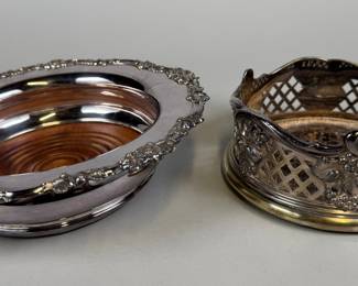 Two Silverplate Wood Lined Wine Coasters. One pierced with grape vine motifs marked JS - H: 2 1/2 x dia: 5 1/2 inches; One with scrolling foliate edge, unmarked, H: 2 x dia: 8 3/4 inches