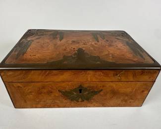French Wood Jewelry Box With Floral Brass Inlay, C. 1915, stamped MADE IN FRANCE to underside, orange fabric lining, circa first half 20th century, H: 3 inches x w: 8 inches x d: 5 1/2 inches
CONDITION: chip to top left corner, back corner brass lifting, does not come with key