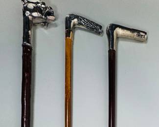 Three Silver Mounted Dress Walking Sticks (3). Textured Grip: Sterling 26 gauge, Sterling, loss on wood inlay on grip, silver tone ferrule
Dog Grip: Labeled "fine silver," scuffing along shaft, silver tone ferrule
Smooth Grip: Sterling, handle loose from shaft, silver tone ferrule