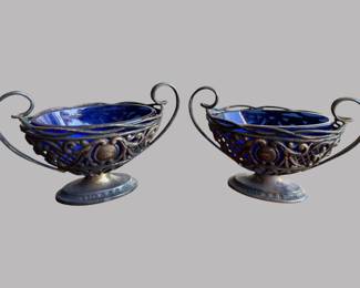 Two .800 Silver Boars And A Pair Of English Salt Baskets With Cobalt Glass Liners (5), the two boars stamped .800 to rim of head interior, Largest: 3 1/4 inches length; a silver plated boar, stamped GERMANY; the pair of English silver baskets with full hallmarks to side, H: 2 1/4 x w: 4 x 1 7/8 inches
CONDITION: salts dark with tarnish