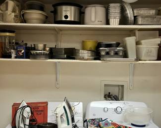 (WASHER AND DRYER NOT FOR SALE) vintage irons, electric irons, ironing boards, lots of baking and cooking supplies, some vintage and some Tupperware brand containers.