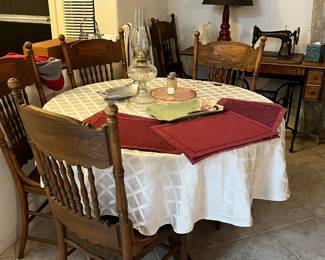 6 early 1900's dining room chairs and table with 2 leaf inserts, oil lamp, 1887 singer sewing machine, lamp, place mats and more