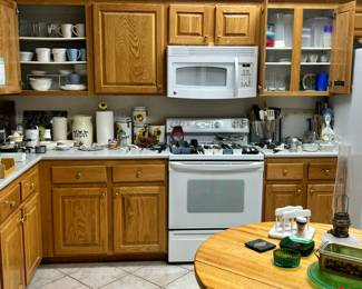 silverware, knives, measuring cups, kitchen utensils, vintage canisters, pitchers, Corelle dinnerware and mugs, lots of storage utensils, glasses, vintage aluminum kitchen items, crystal and more.