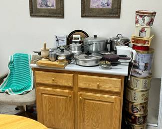 decor, pots and pans, vintage icing, cupcake and other tins, wood block, electric water warmer/tea pot ,lots of tins, chair and crotchet item.