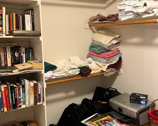 sheets, books, vintage end table, printer hp, towels, hand towels, wash cloths, vintage hamper, some records, luggage and magazines, samsonite and one other briefcase