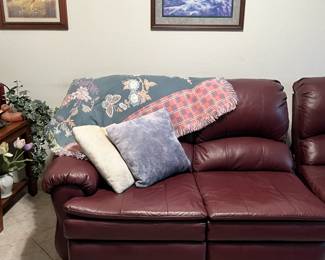 other part of sectional, wall art, pillows and a blanket
