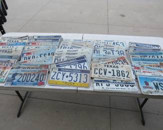 Lot 56. Tabletop full of license plates