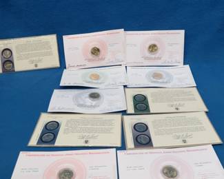 Lot 39. Seven gold-plated presidential dollar coins, and four Liberty and Prosperity two - quarter sets.