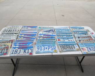 Lot 58. Tabletop full of license plates