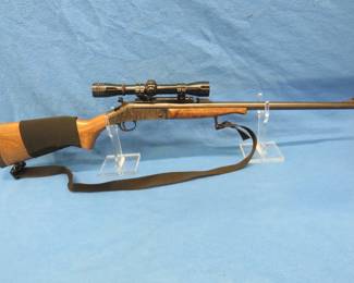 Lot 28. New England Firearms Pardner Tracker 20-gauge single shot shotgun. Includes 24" rifled barrel, sling, ammunition sleeve, and a 4X Redfield scope.