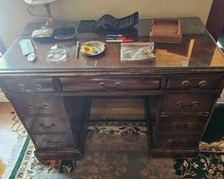 Old wooden desk with protective glass top, Men's silver hairbrushes, Desk or side table lamp, Travel folding keyboard, Wooden box