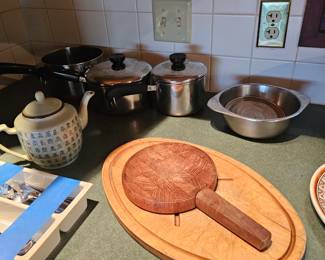Large oval wooden cutting board, Cutting board with knife inside handle, tea pot, Sauce pans, sauce pots