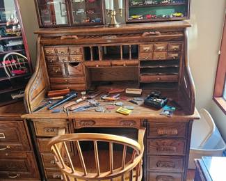 Wooden roll top desk, Wooden wheeled desk chair, Die cast cars in case, desk lamp