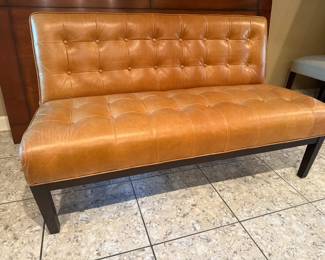 Two seater tufted leather bench/couch. Lovely caramel color, dark brown wood legs. Height sitting area 18.5", w/back support 33",D 27"