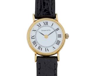 1184
Tiffany & Co.: A 14K Gold Watch
Dial:19.98 mm, round with Roman numeral hour markers
Case: 22.70 mm
Closure: black leather strap with gold plated buckle clasp
Signed: dial
Inner circumference: 6 - 7 in.
15.9 grams gross
Estimate: $800 - $1,200