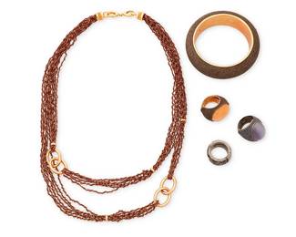 1073
Pesavento: A Group of 'Polvere Di Sogni' and Sterling Silver Jewelry
Four works by Pesavento, featuring a chunky domed bangle bracelet with bronze brown 'polvere' powdered glitter on rose gold-plated sterling silver, as well as two sterling silver polvere and set stone cocktail rings, one rose gold-plated with orange glass cabochon and one darkened sterling silver with purple glass cabochon, plus a gunmetal sterling silver wide ring band with chain mesh detail, and a stretchy multistrand brown and vermeil chain mesh necklace with gold-toned oval link accents and double lobster claw clasp, four signed and with Italian assay marks, necklace marked for sterling
5 pieces
Necklace: 32 in. L approximately; Bangle: 8 in. inner C.; Ring sizes: 8 & 7 1/2
186.5 grams gross
Estimate: $700 - $900