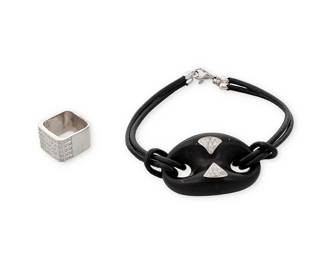 1178
A White Gold and Diamond Ring and Bracelet
Including a square 14k white gold ring set with round diamonds weighing approximately 1.00 carat, together with and 18k white gold, wood and cord bracelet accented by round diamonds
2 pieces
Ring: 4, Bracelet: 8 in.
16.2 grams gross
Estimate: $400 - $600