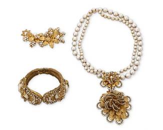 1096
Miriam Haskell: A Group of Vintage Costume Jewelry
Three works in gold-toned metal with faux pearls and rhinestones comprising a front-clasp choker necklace with a large floral pendant suspended from two strands of faux grey pearls, together with a hinged cuff bracelet with large faux pearls and oval terminals, as well as a brooch featuring multiple gold-toned leaves and seed pearl clusters, each signed to plaque verso
3 pieces
Necklace: 14 1/2 in. L x 3 in. H; Cuff: 6 in. inner C; Brooch: 1 /1/2 x 3 in.
190.1 grams gross
Estimate: $700 - $1,000