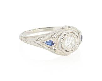 1155
An 18K White Gold, Diamond and Synthetic Sapphire Ring
Centering an old European-cut diamond weighing approximately 0.25 carat, accented by two kite shaped synthetic sapphires
Size: 7
2.3 grams gross
Estimate: $400 - $600