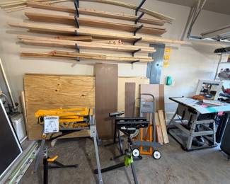 Variety of unused wood - 2X4s, 2X6s, full sheets of plywood; plywood moving dolly, variety of work benches and stands