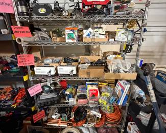 Extension cords, power strips (bottom shelf) sanders and variety of sandpaper and sanding blocks (second the bottom shelf), variety of wheels for carts/tables etc (middle shelf), home improvement accessories, outlets, light switches, thermostats, faucet (second from top; work lights and heating tools (top shelf) 