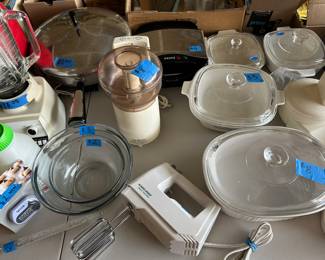 Top: Sunbeam Oscar chopper, hand mixer, white casserole dishes with covers, candy thermometer