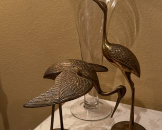 brass herons and large glass vase
