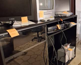 Various electronic equipment  -  TV/DVD players and screens, VHS player, and cabinet.