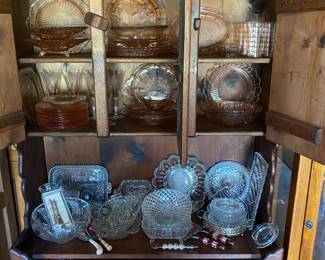 Pink glassware on upper shelf, cut and pressed glass on lower shelf.