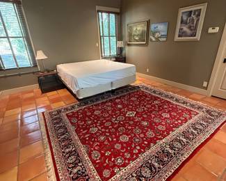 King size bed and lovely area rug. Art can be found throughout the house.