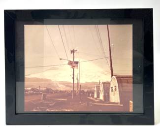 Striking Vintage US Military Outpost Photograph, c. WWII-1950s, Featuring Quonset Huts and American Flag Against a Majestic Snowy Mountain