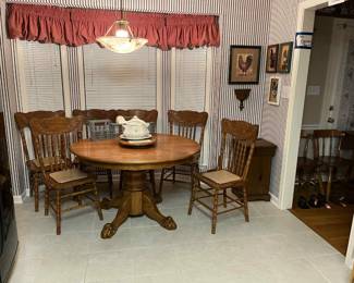 1976 Claw foot solid table with leaf, lazy susan and 6 press back chairs. Soup turine, chicken pictures, wooden trash can, vintage home interiors planters