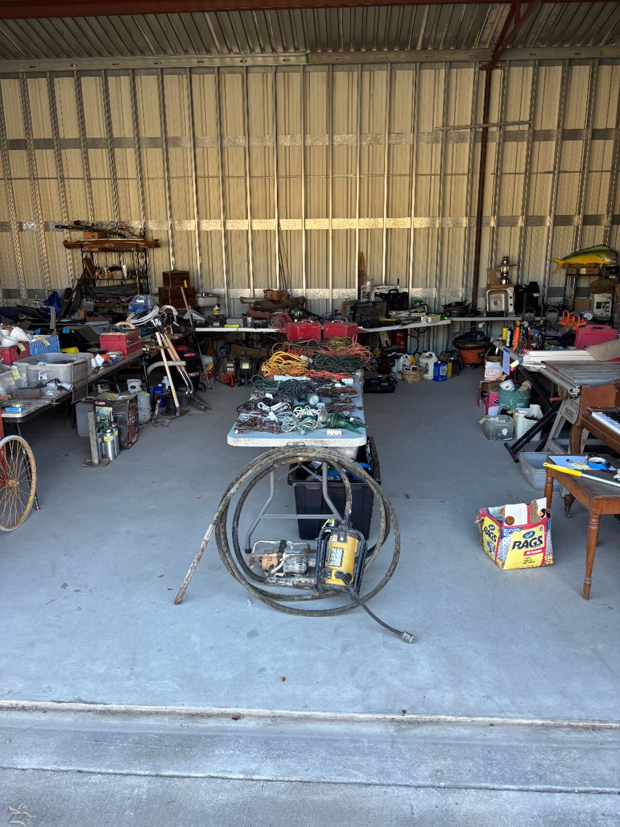 This is a wide shot of one section of the cell lots of tools Concrete vibrators whole table of extension cords multiple power tools back there on the back tables quickie sauces, piano table, saw nothing behind the tables is for sale