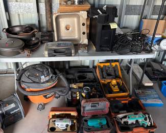 These are lasers and level equipment down on the ground for shooting grades at the total station on the far right bottom transit for shooting grades shop vac whole pile of cast-iron wear Dutch oven skillets of multiple varieties pots all cast-iron and entire Bose surround sound system sink really really fancy lantern lantern on top comes brand new in the wooden crate box