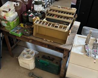 Fishing supplies, camping supplies, propane bottles, tackle boxes, fish, baskets, Coleman, lanterns storage tubs, dog food, storage tub, and a dumbbell