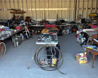 This is a wide shot of one section of the cell lots of tools Concrete vibrators whole table of extension cords multiple power tools back there on the back tables quickie sauces, piano table, saw nothing behind the tables is for sale