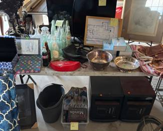 Household goods, two heaters underneath the table some pictures old antique bottles a television, two decorative lamp lights a few purses little things