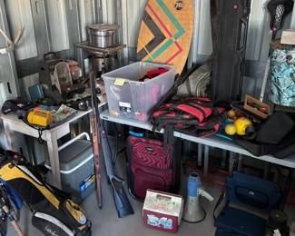 More sporting goods, golf clubs, pellet, guns, ice, chest couple igloos stadium chair, skim board, bean burner back in the back flashlight instead of white tail antlers left side edge of this picture lifejackets set of pool balls deer feeder lacrosse stick gun case suitcase heater for camping hot tub of athlete, socks for baseball or softball, maroon color and pink a few other items, megaphone electronic megaphone